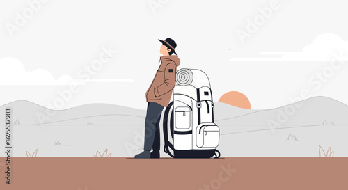 A lonely hiker standing next to a backpack contemplating a landscape at sunset