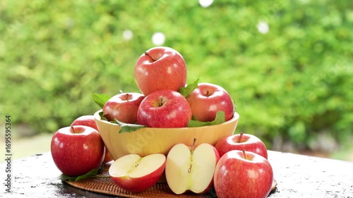 Red Applw on green nature bokeh background. Many Red apples in basket on wooden table.