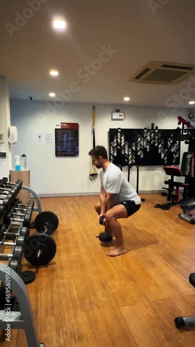 Real-life gym workout scene filmed in a small indoor fitness studio. The footage captures a person performing a strength or cardio exercise using basic gym equipment. Ideal for content related to home