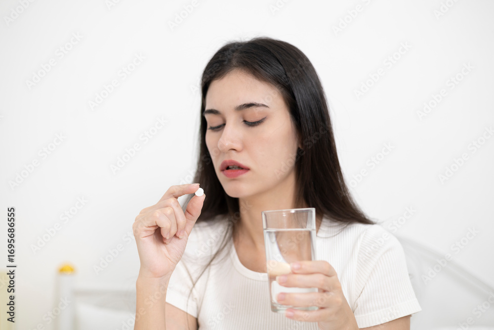 A sick woman picks up medicine to eat and drink while at home. Health care A sick woman picks up medicine to eat and drink while at home. Health care