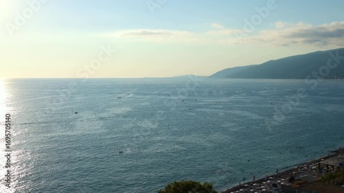 A sea view with mountains and clouds.