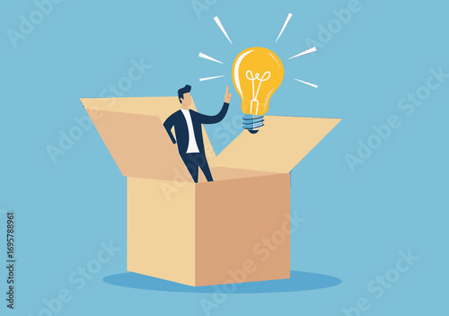Businessman standing inside open cardboard box with glowing light bulb representing creative idea innovation thinking and problem solving concept