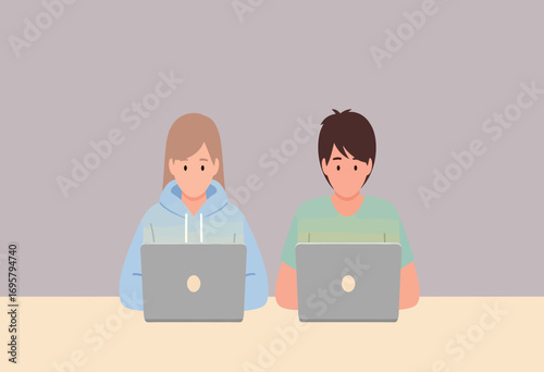 A young man and woman sitting at a desk and working on their laptops. Concept of teamwork, freelancing, education, or modern digital lifestyle