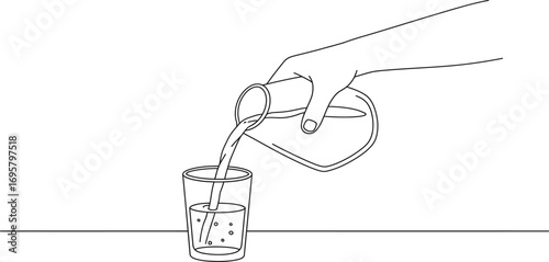 a hand pouring liquid into a glass on table