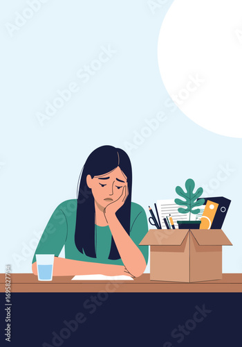Young woman looking sad and dejected sitting at a desk with a box of office supplies indicating a job loss or redundancy