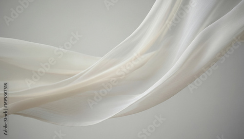 Flowing sheer white fabric draped against a neutral background with soft light, forming an abstract airy effect that emphasizes texture and elegance.