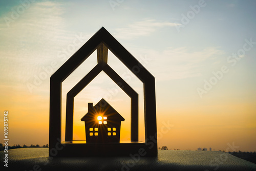 Fotografie Wooden house silhouette with layered frame and sunlight, symbolizing multi-level home security, protection, peace of mind, family safety, smart housing, and secure residential property