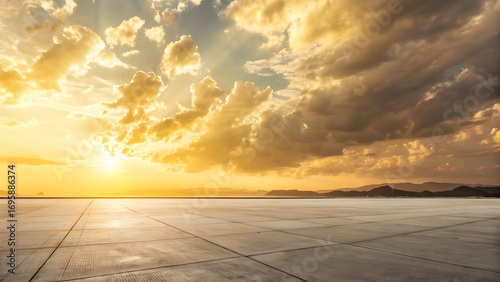 Fototapeta Naklejka Na Ścianę i Meble -  Dramatic golden sunset sky with textured clouds over a vast flat reflective landscape