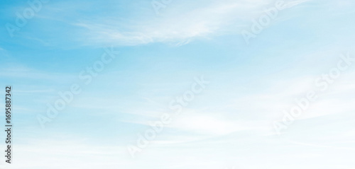 Light blue sky with soft white clouds gently fading to white at the bottom, creating a serene and airy atmosphere with subtle natural gradients and calm daylight.