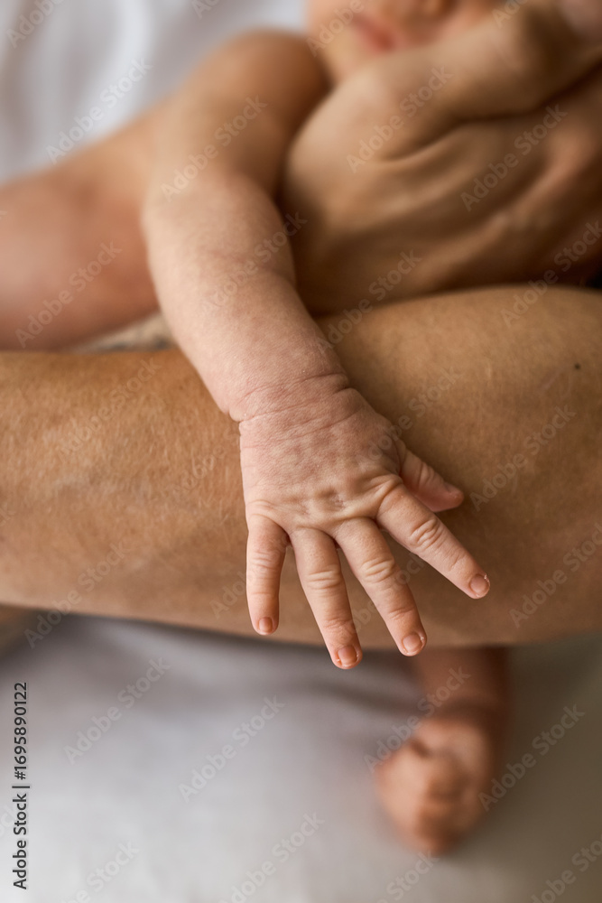 Fototapeta premium Newborn Baby's Hand Holding Adult's Arm