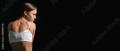 Young skinny woman on dark ...