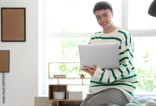 Young man in eyeglasses usi...