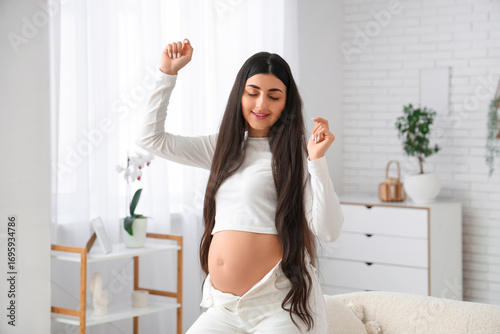Young pregnant woman dancin...