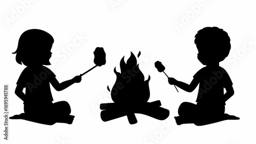 Silhouette of two children roasting marshmallows over a campfire with logs and bright flames at night time