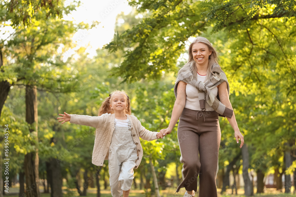 Fototapeta premium Little girl with her mother running in park on autumn day