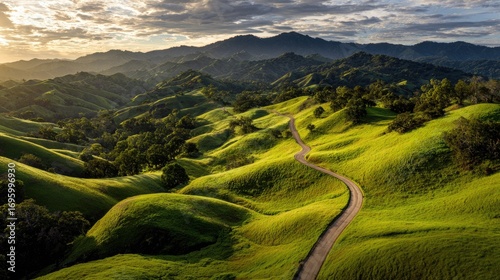 Winding road through lush green hills under a cloudy sky.