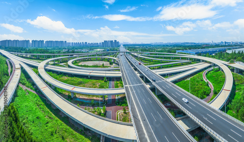 Canvas-taulu Aerial view of a complex highway interchange with multiple overpasses and curved ramps on a sunny day