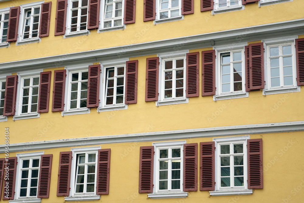 Fototapeta premium Facciata di Edificio Storico Giallo con Persiane Scure