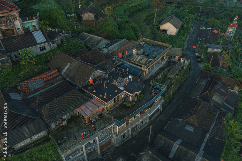 Naklejka premium Aerial view of a rural village with green hills