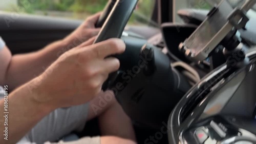 Man driving car. hand on the steering wheel against the background of the road on sunny day
