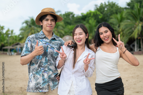 Three happy young friends at beach smiling together