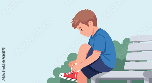 Young boy sitting on a park bench tying his shoelaces.