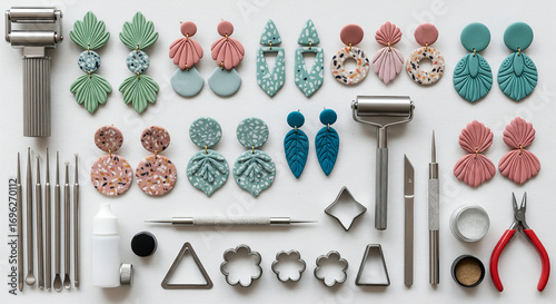 A flat lay of polymer clay earring making supplies and finished earrings, including cutters, tools, and various earring designs.