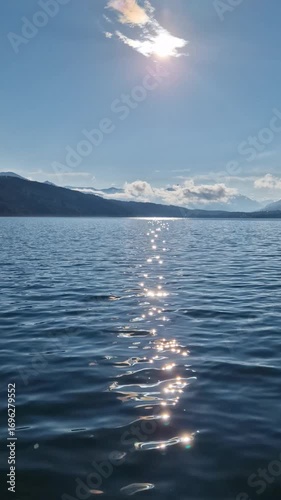 Magical sunlight sparkling on pure lake water, creating a serene and meditative panorama.