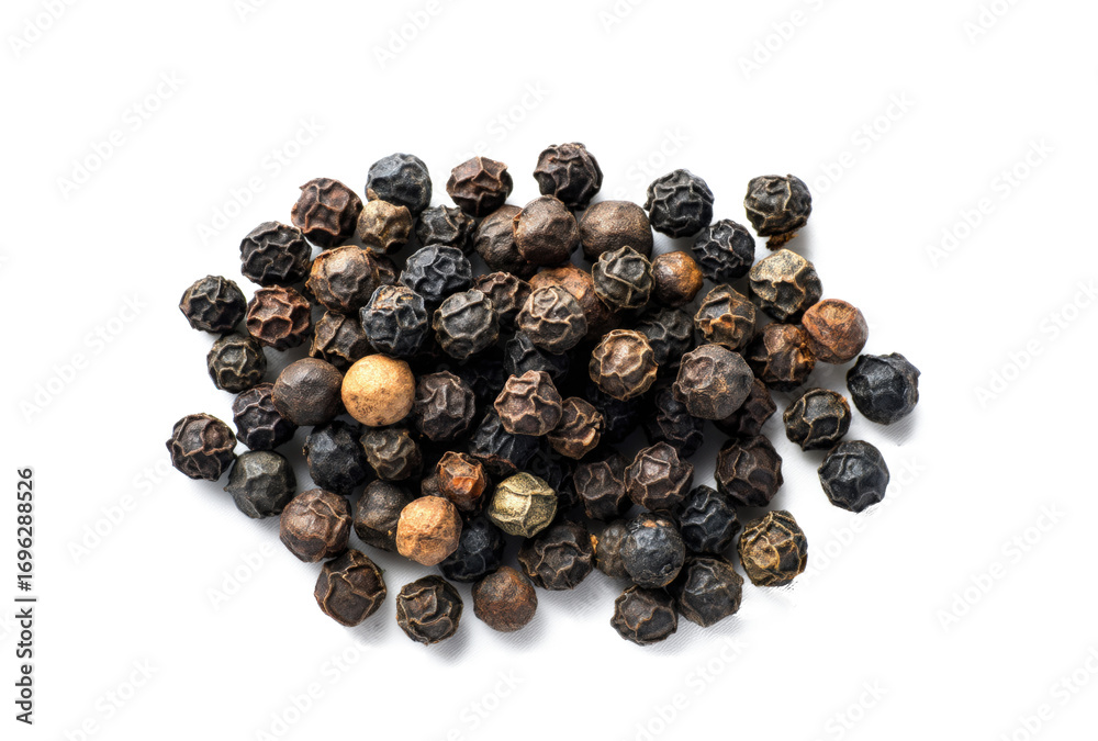 Obraz premium Black peppercorns scattered on a white background, top view
