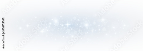 Glistering blue bokeh with sparkling stardust and festive confetti. Magical light and glittering particles forming a vibrant Christmas card effect.