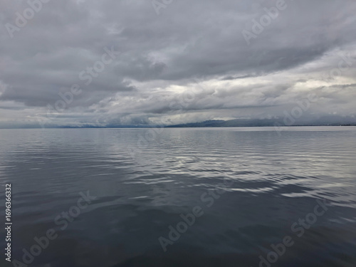 scenic view of calm gray sea with cloudy sky