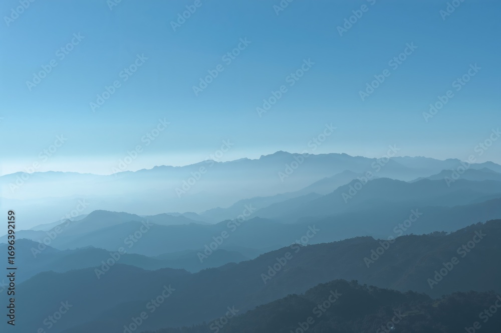 Naklejka premium Silhouetted peaks under a hazy azure sky on a sunny day, beautiful natural landscape in a European region