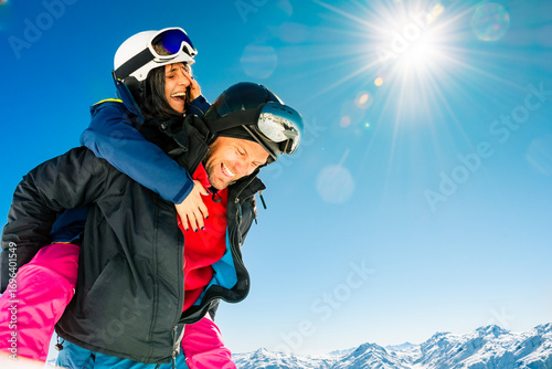 Fotografía Happy young caucasian skiers couple in love having fun together playing in mountains piggybacking at wintertime