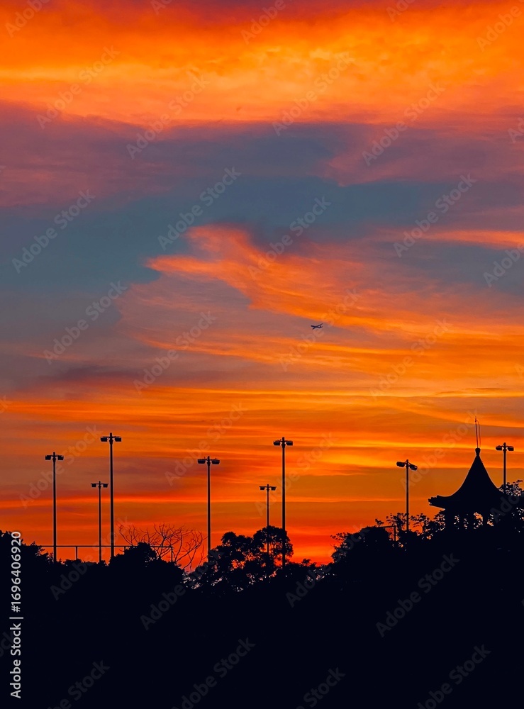 Fototapeta premium Vibrant Sunset with an Airplane and Gazebo Silhouette