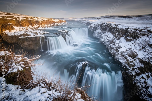 Winter evening scene at a majestic waterfall under twilight skies