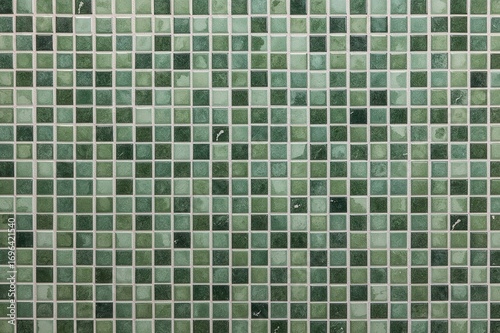 Background of green ceramic mosaic tiles with a vintage style for interior wall or floor decoration. Various shades of green ceramic tiles for home decor.
