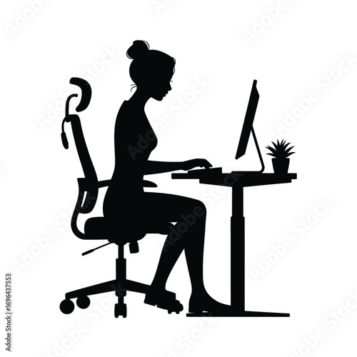 Silhouette of a woman working at a computer on an adjustable desk
