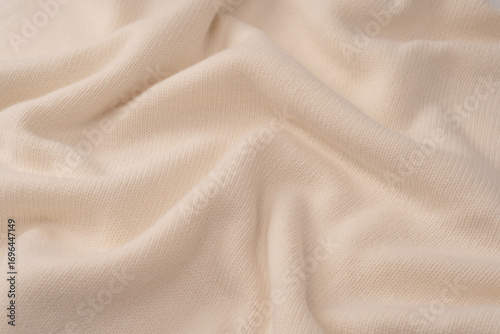 Soft milky color merino wool sweater texture as a background.