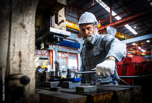 Technician industrial worker inspecting aluminum metal sheet fabricating roll check stock materials in the steel coil storage area, rolls metal sheet high quality durable meet standards industry.