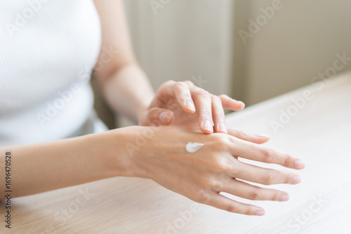 Healthy skin care, beauty asian young woman hand applying moisturizer, putting cream treatment on back hand after shower bath at home, makeup routine in the morning, treatment skin care body concept.