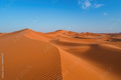 Fototapeta Naklejka Na Ścianę i Meble -  Stunning aerial shots of golden dunes under a vibrant blue sky