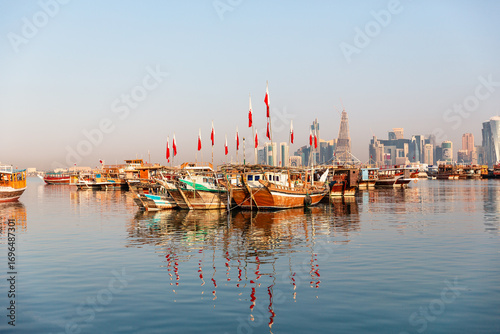 Obraz na plátně Evening view of Doha Bay with traditional wooden dhow fishing boats along the Corniche, seen from the Museum area in Doha, Qatar – stock photo