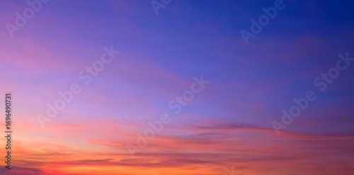 Twilight sky background with natural light and colorful orange sunlight cloud on blue evening sky in panoramic view