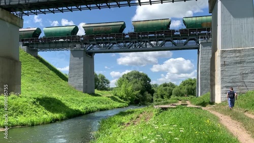 A train carrying freight cars travels across a bridge over a river.