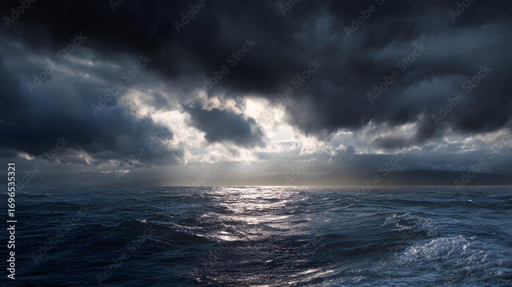 Fototapeta premium Dramatic seascape showcasing a stormy sky with light piercing through dark clouds over a rippling ocean.