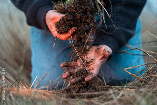 Tableau sur toile farmer collecting soil samples in a test tube in a field