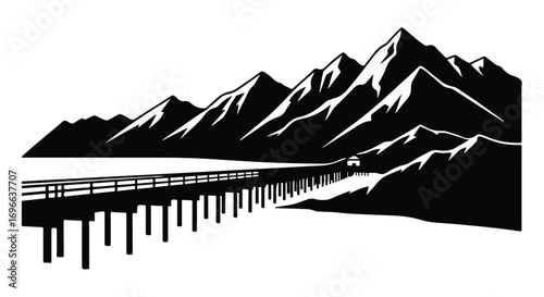Scenic road stretches towards majestic mountains under a vast sky