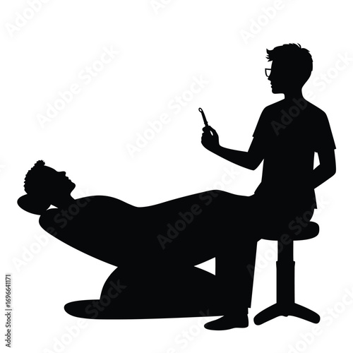 Dentist with glasses examining patient in reclining chair
