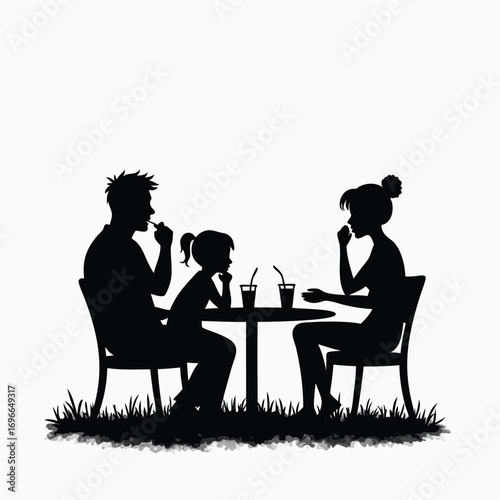 Family silhouette eating at outdoor table with drinks