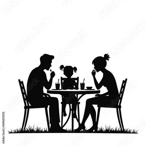 Family silhouette eating at outdoor table with drinks